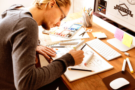 Creative designer sketching website wireframes at desk