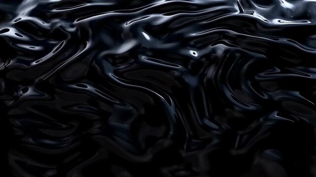Slow motion close up of black liquid surface rippling and flowing under studio lights in dark studio setup