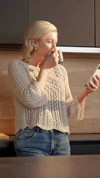 Coffee, woman and laugh with phone in home for internet meme, funny online video and streaming. Beverage, mature person and happy with mobile in kitchen for reading comic status, social media or joke
