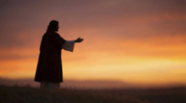 Artistic silhouette of a man in a robe with outstretched arms against a colorful sunset sky, standing on a grassy hilltop. Biblical scenes, suitable for religious content, Easter concept