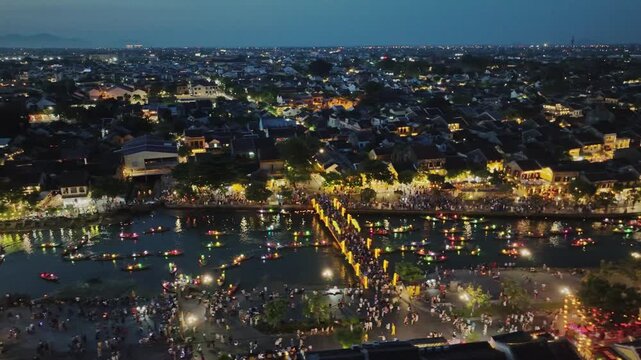 Aerial perspective of a busy pedestrian bridge crossing the Thu Bon River in Hoi An.
