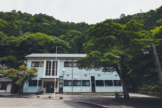 田舎の山間部に建つレトロな木造校舎の外観,
