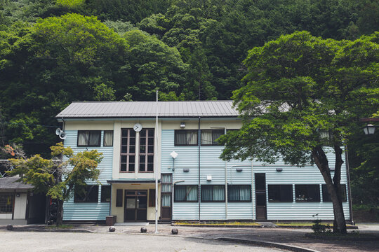 田舎の山間部に建つレトロな木造校舎の外観,
