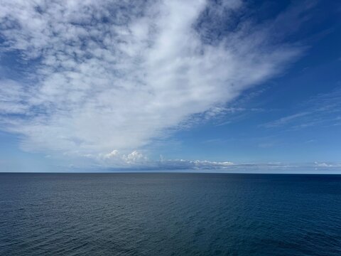 Sky clouds over calm blue sea 