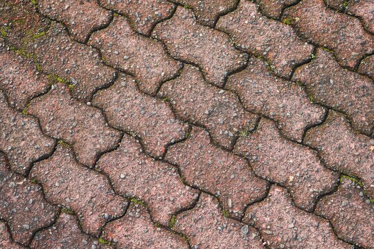 Aged red interlocking paving brick stone floor texture background