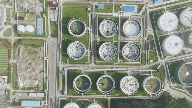 Aerial view of wastewater treatment plant with circular settling tanks and pipelines