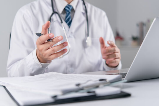 Medical specialist gesturing hands while providing online telehealth consultation via laptop on office desk highlighting virtual doctor appointment and professional clinical advice