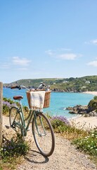 Fototapeta premium Bicycle with basket parked on coastal path overlooking scenic beach