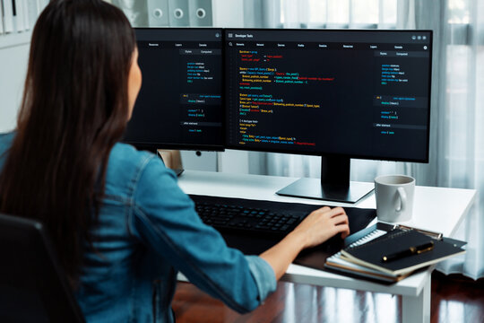 Young Asian in IT developer creating with typing online information on pc with coding program data of website application, wearing jeans shirt. surrounded by safety analysis two screens. Stratagem.