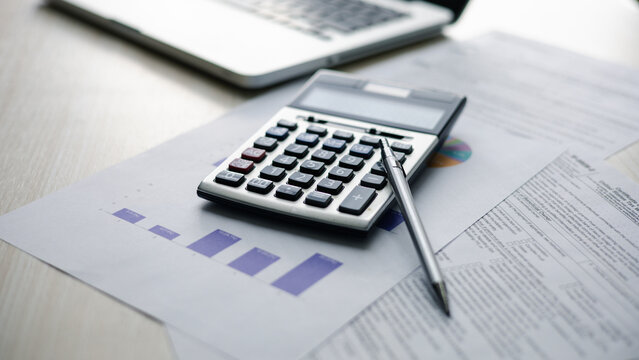 audit auditing auditor.Calculator, financial reports, tax documents, and laptop on an office desk illustrate accounting, auditing, budgeting, financial analysis for business planning and compliance.