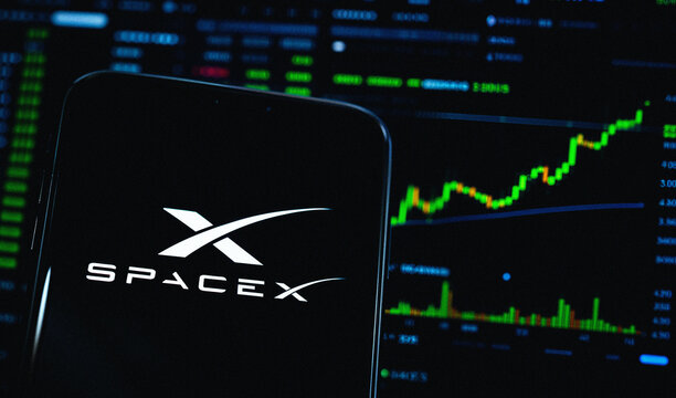 Smartphone Displays SpaceX Logo, Trader Workstation Displaying Green Bullish Stock Market Candlestick Charts, SPCX Initial Public Offering (IPO) Graph, London, United Kingdom - June 2026