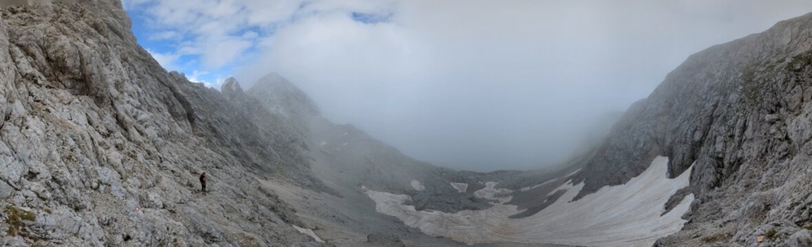 Panoramic view of Logarska dolina valley with peaks of Slovenian Alps covered by passing clouds.