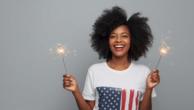 Cheerful african american woman holding lit sparklers wearing american flag t-shirt celebrating national holiday
