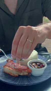Foodie squeezing calamansi juice on top of fried chicken or pritong manok and using the fork to strain the seed showcasing an authentic Filipino local food. Dauin, Philippines
