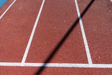 Fototapeta premium Track Surface With White Lines on a Sunny Day During a Sports Event or Training Session