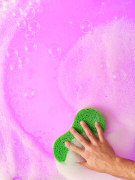Soapy sponge with suds against purple background