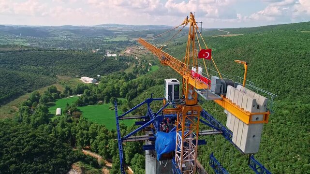 Workers build a viaduct deck with a blue gantry system above a green valley, highlighting bridge construction, safety gear, crane operations, highway infrastructure and civil engineering progress.