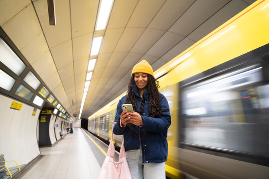 Woman Using Phone in Subway Station 