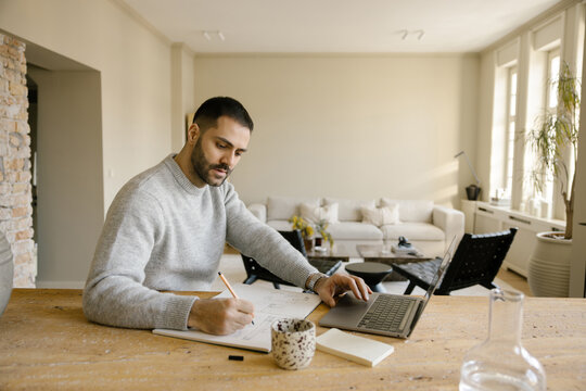 Man Working at a Desk in a Modern Living Room During Daytime