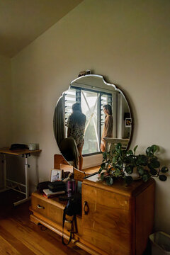 Sisters watching storm through bedroom mirror