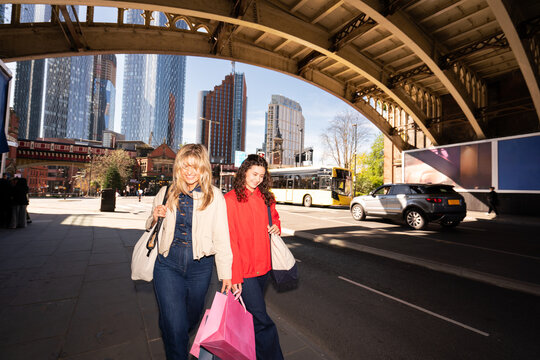 Two Women Walking in a City With Shopping Bags