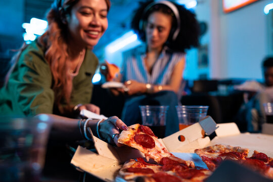 Friends enjoy pizza and drinks in a casual setting.