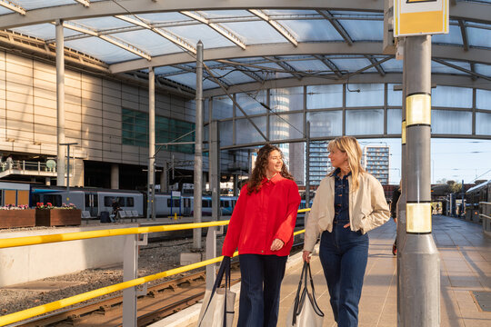 Two Friends Walk at the Train Station 