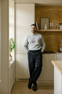 Man Stands in Modern Kitchen During Daylight Hours