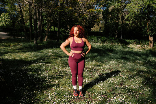 A full-length portrait of a curvy woman in athletic wear