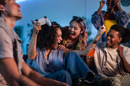 Friends celebrate a video game victory with joy.