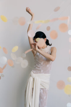 Elegant dancer in sheer dress, minimalist backdrop