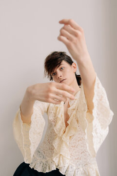 Expressive editorial portrait with lace ruffle blouse indoors
