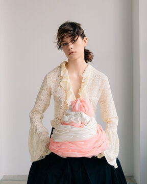 Editorial fashion portrait with lace blouse and pastel sculpture
