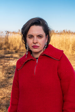 Woman in red sweater portrait in dry grass field