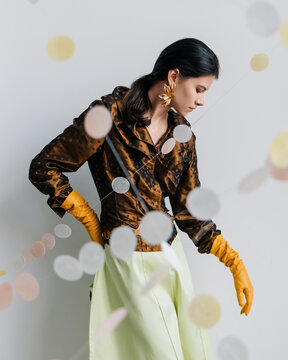 Fashion editorial with confetti garlands and golden gloves