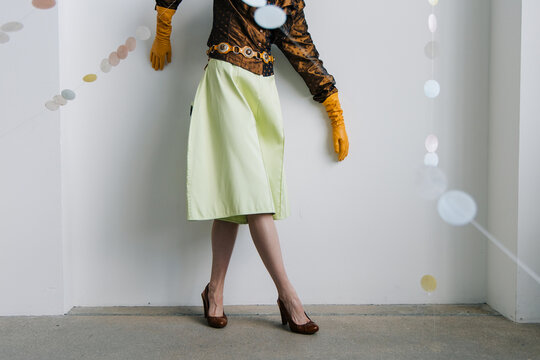 Editorial fashion styling with satin blouse and citrus gloves