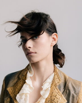Cinematic fashion portrait with windswept hair and ruffled lace