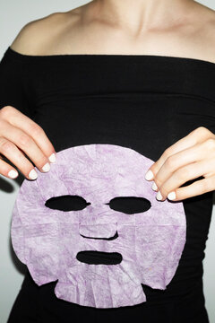 Person peeling of a beauty cosmetic facemask with hard flashlight