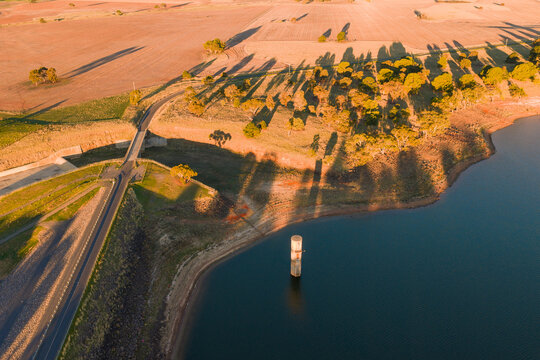 Long shadows cast in golden light over a reservoir embankment