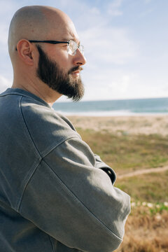 Serious Bearded Man Standing Near Beach in Sunlight