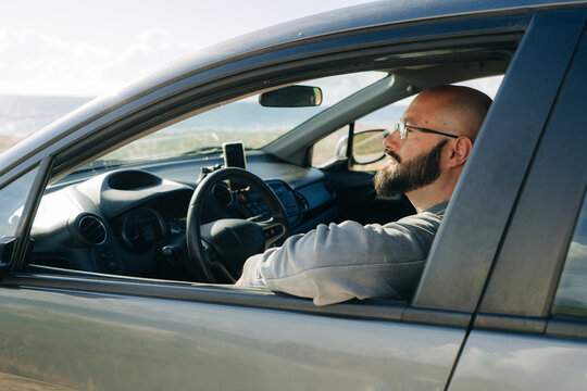 Man Relaxing in Car Near Ocean Coastline