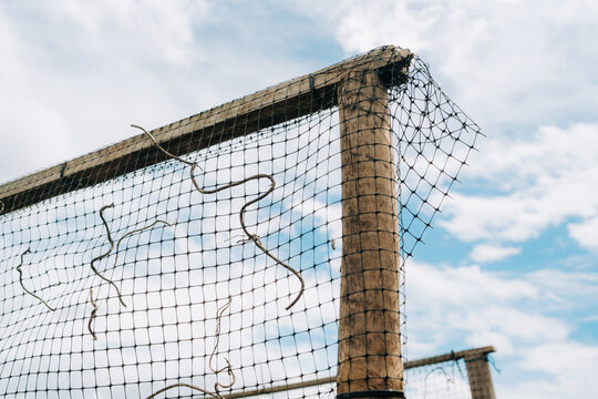 Rustic Wire Fence Against Blue Sky and Clouds