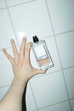 Hand holding classic style mockup perfume bottle with space for text