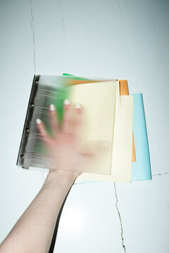 Person holding stylish folder binder full of colorful papers in office