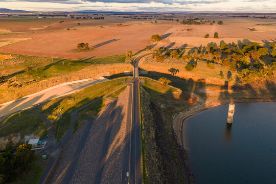 Long shadows cast in golden light over a reservoir embankment