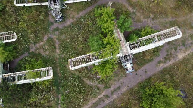 Aerial look down on weathered An-2 Antonov single-engine biplanes abandoned in old airbase field, aviation remains in greenery