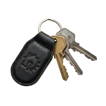 Metal keys attached to a leather fob with a house and gear symbol isolated on transparent background