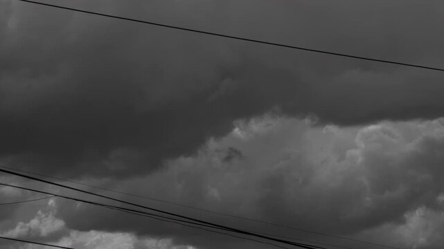 black and white,  cinematic skyscape featuring massive dark cumulus clouds dramatically backlit  the cloud cover. climate change documentation, extreme weather coverage,  El Ni&ntilde;o cycles