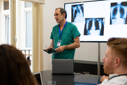 Doctor instructing students on chest radiographs in a modern classroom setting