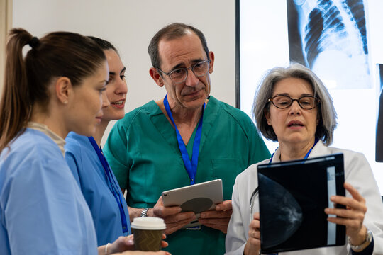 Healthcare professionals discussing mammogram results during a medical meeting